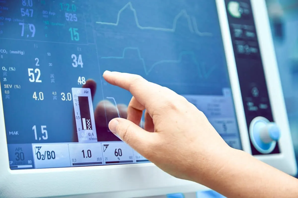 Clinician adjusting settings on a touchscreen patient monitor