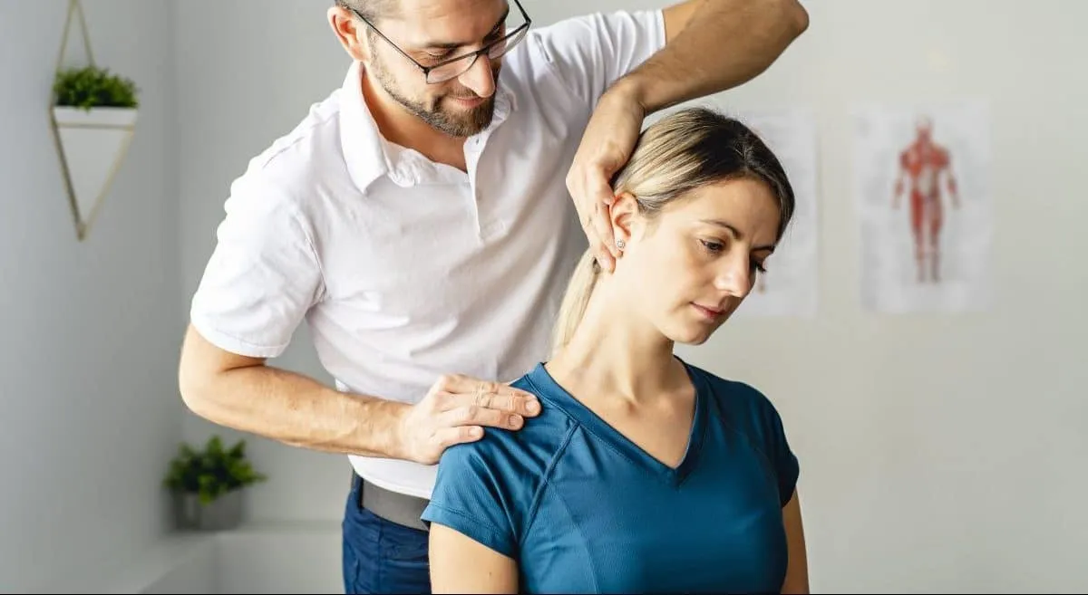 Clinician assessing a patient's neck and shoulder mobility