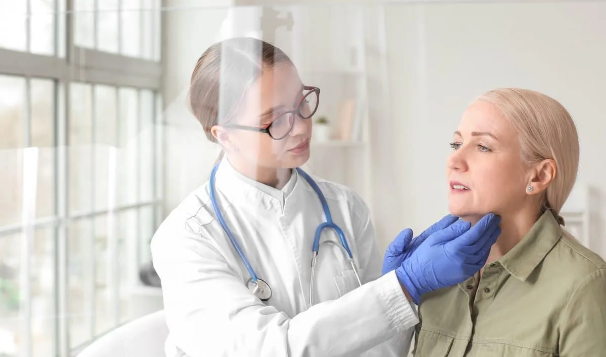 Physician in gloves examining a patient's neck during a checkup