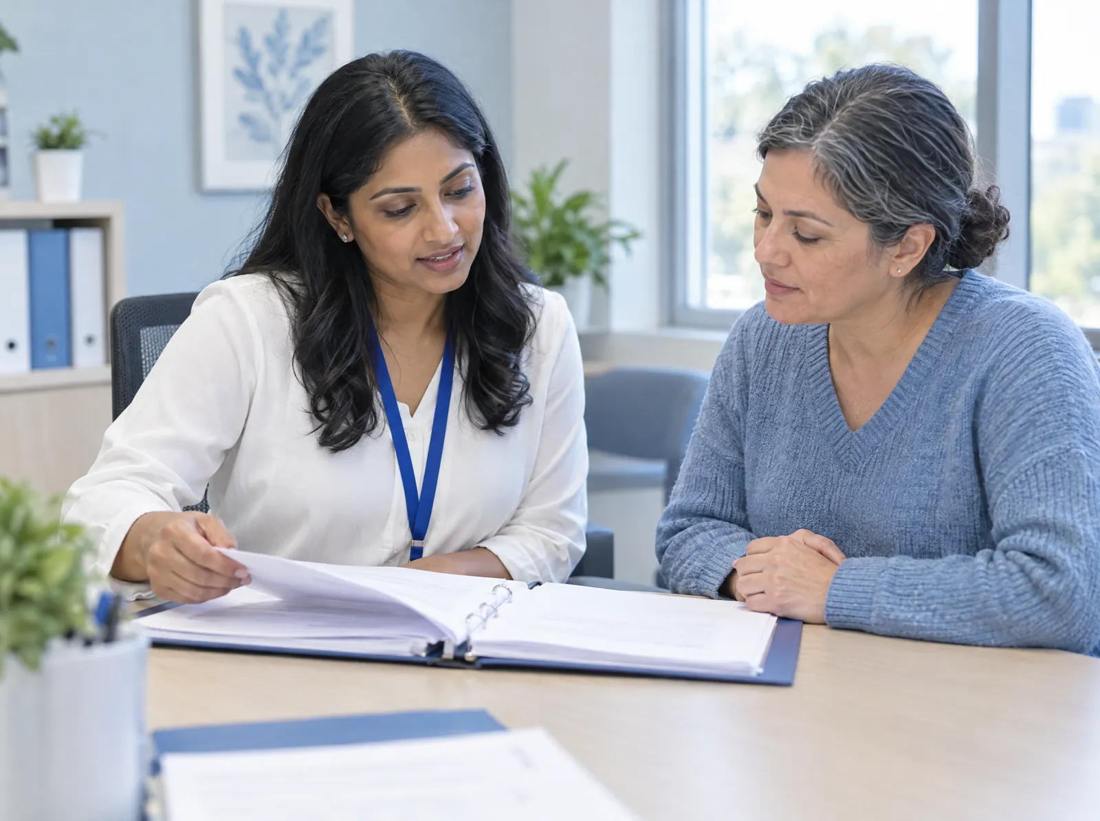RCM software for Clinical Research: clinical research coordinator reviewing a study binder with a participant