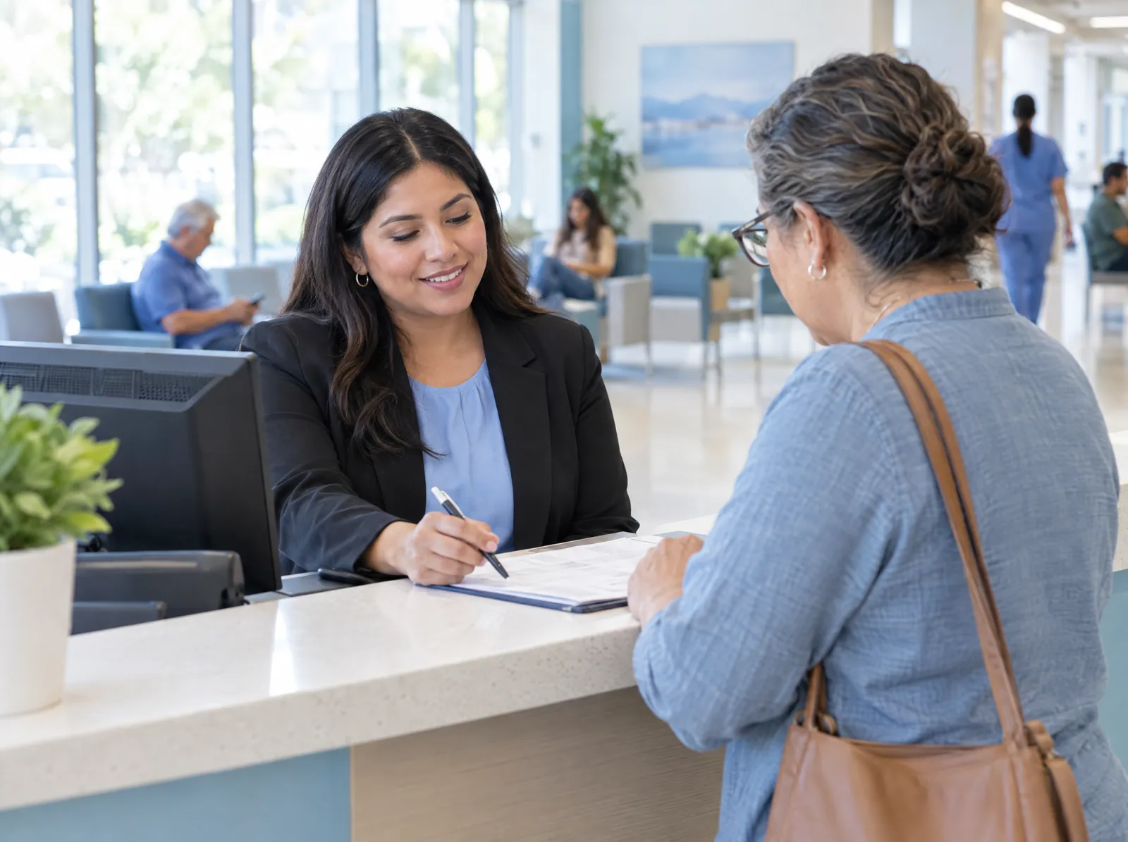 RCM software for Hospital Outpatient: registrar helping a patient check in at a hospital outpatient department