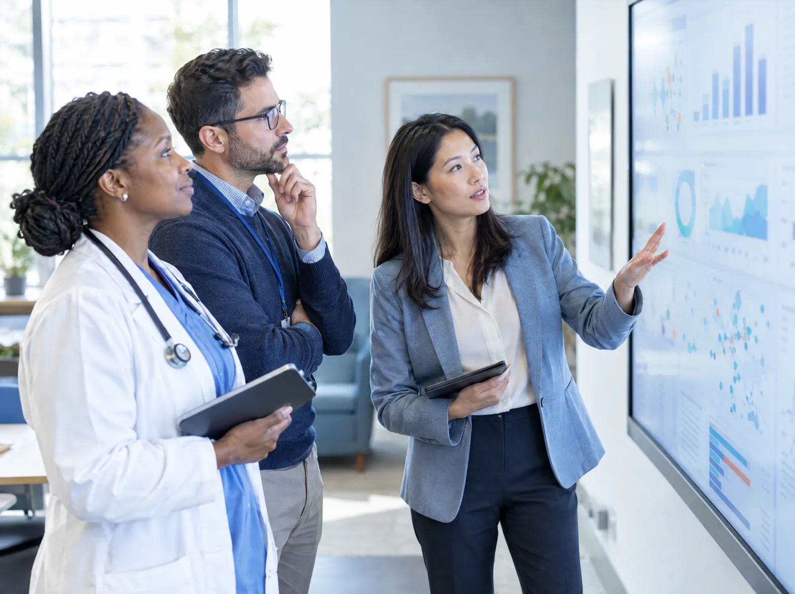 RCM software for Population Health: population health team reviewing care-gap charts on a wall display