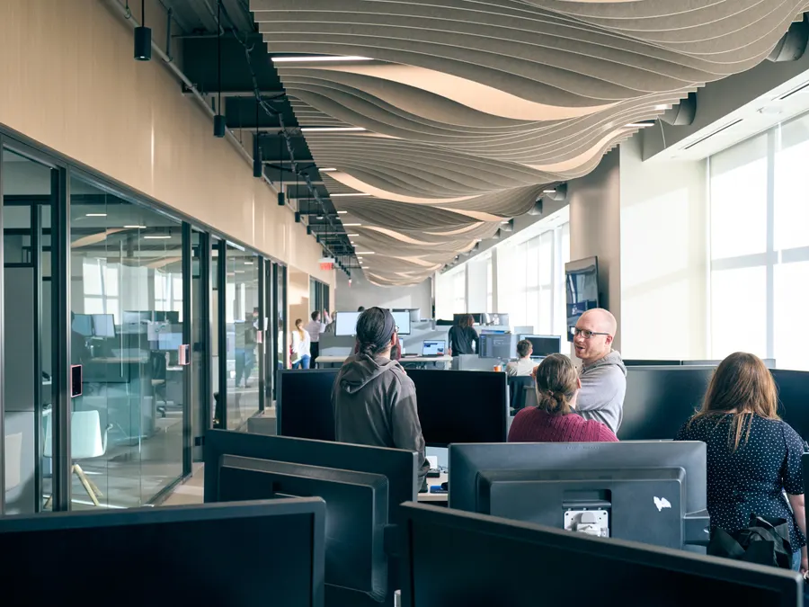 Unlimited Systems team members talking together at their desks in the Cincinnati office