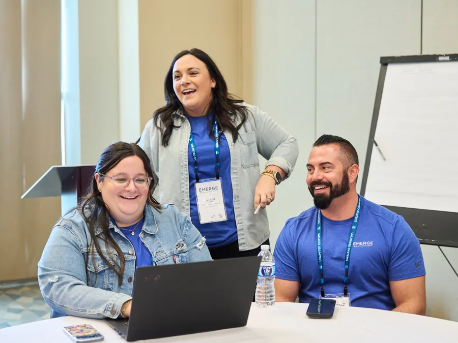 Three Unlimited Systems team members laughing during a working session