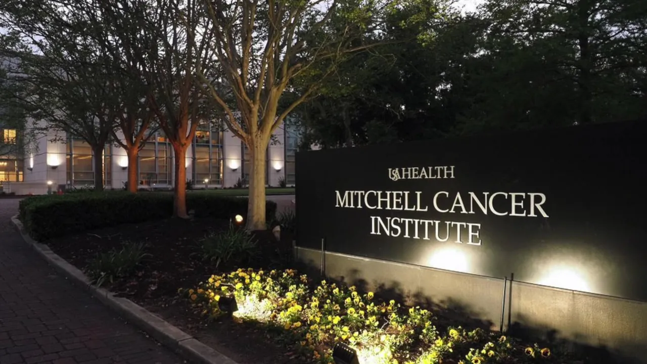 The USA Health Mitchell Cancer Institute sign outside the building at dusk